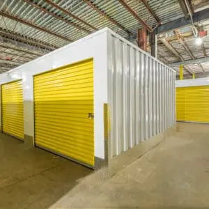 A storage unit with yellow doors and white walls.