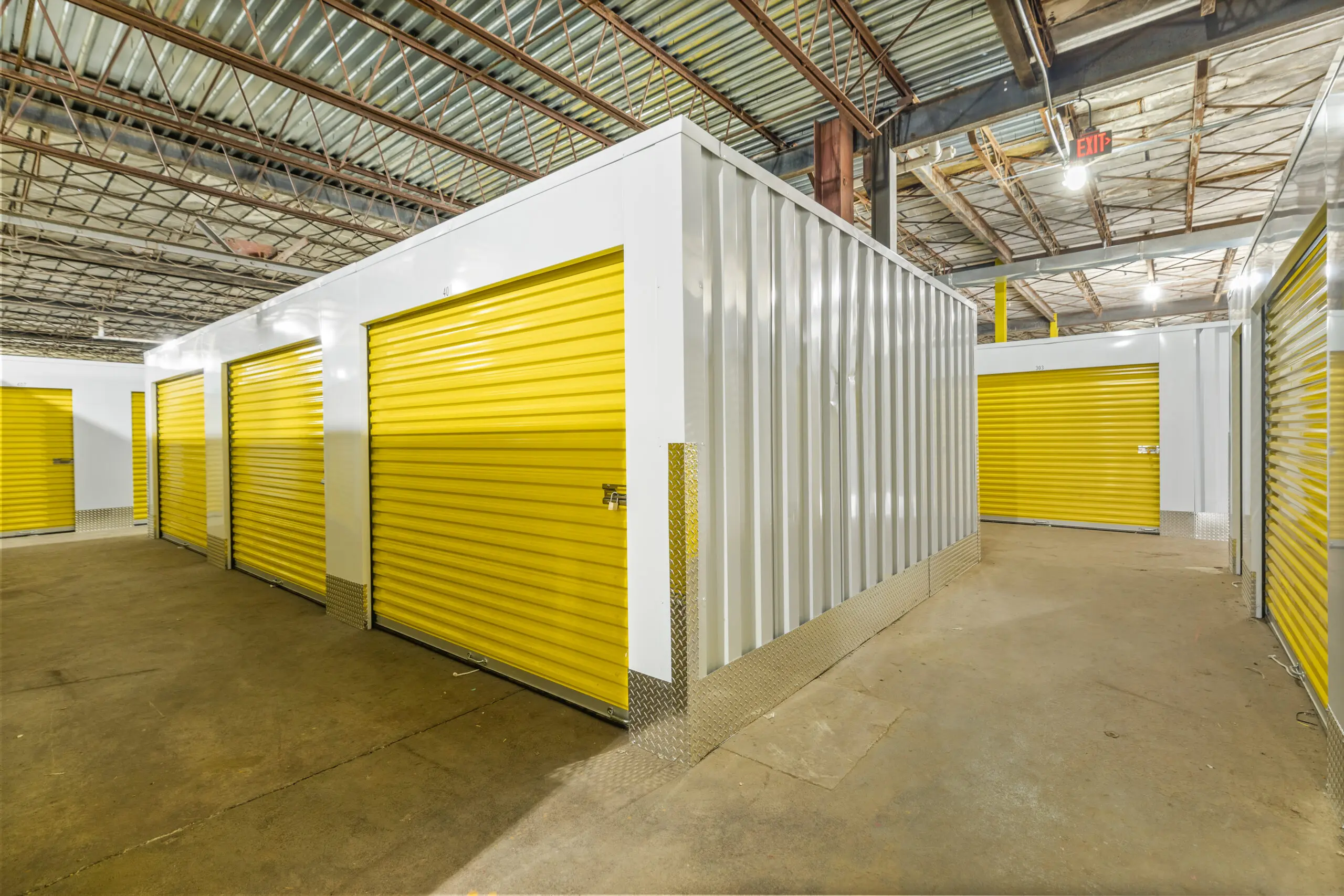 A storage unit with yellow doors and white walls.