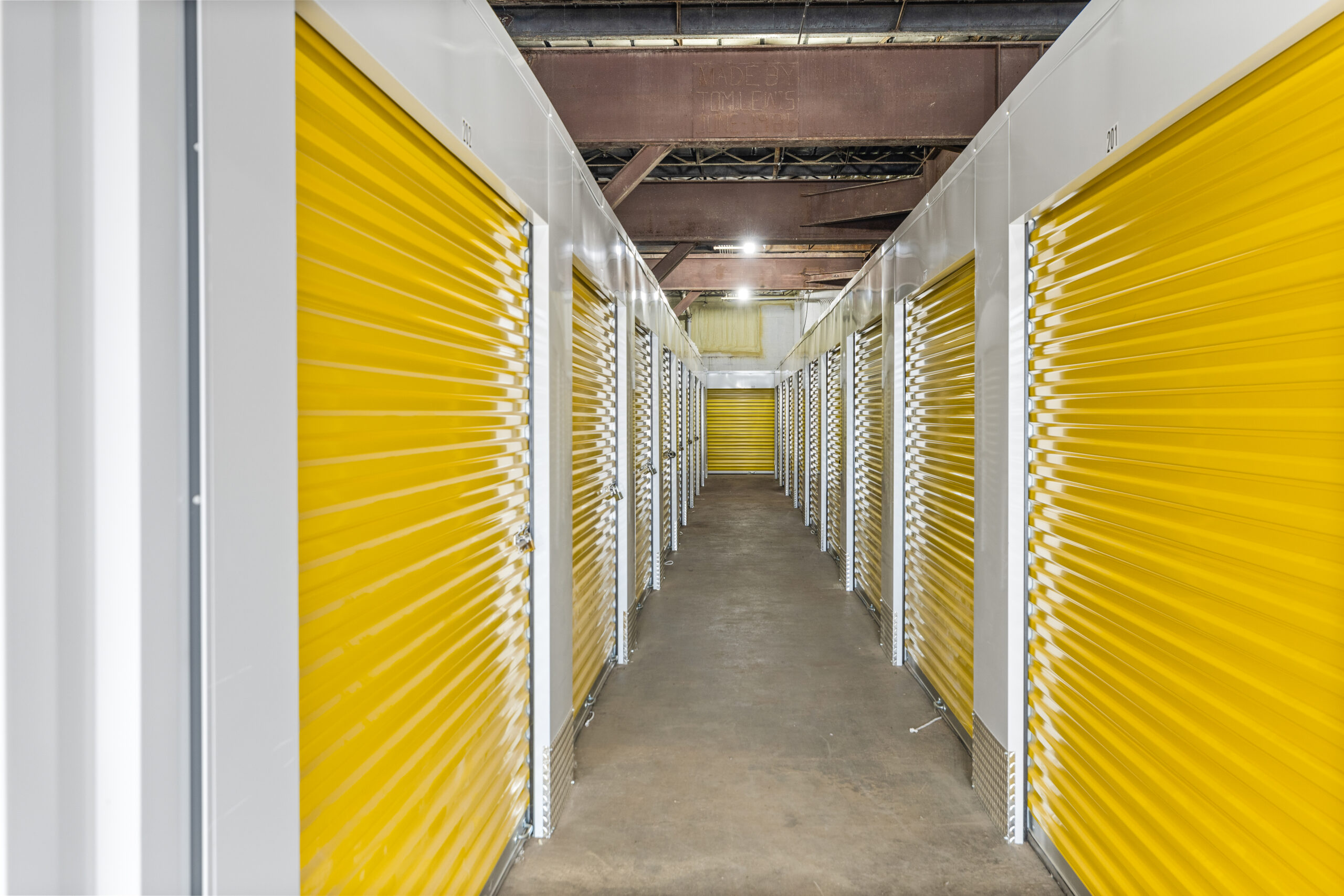 A long hallway with many yellow doors