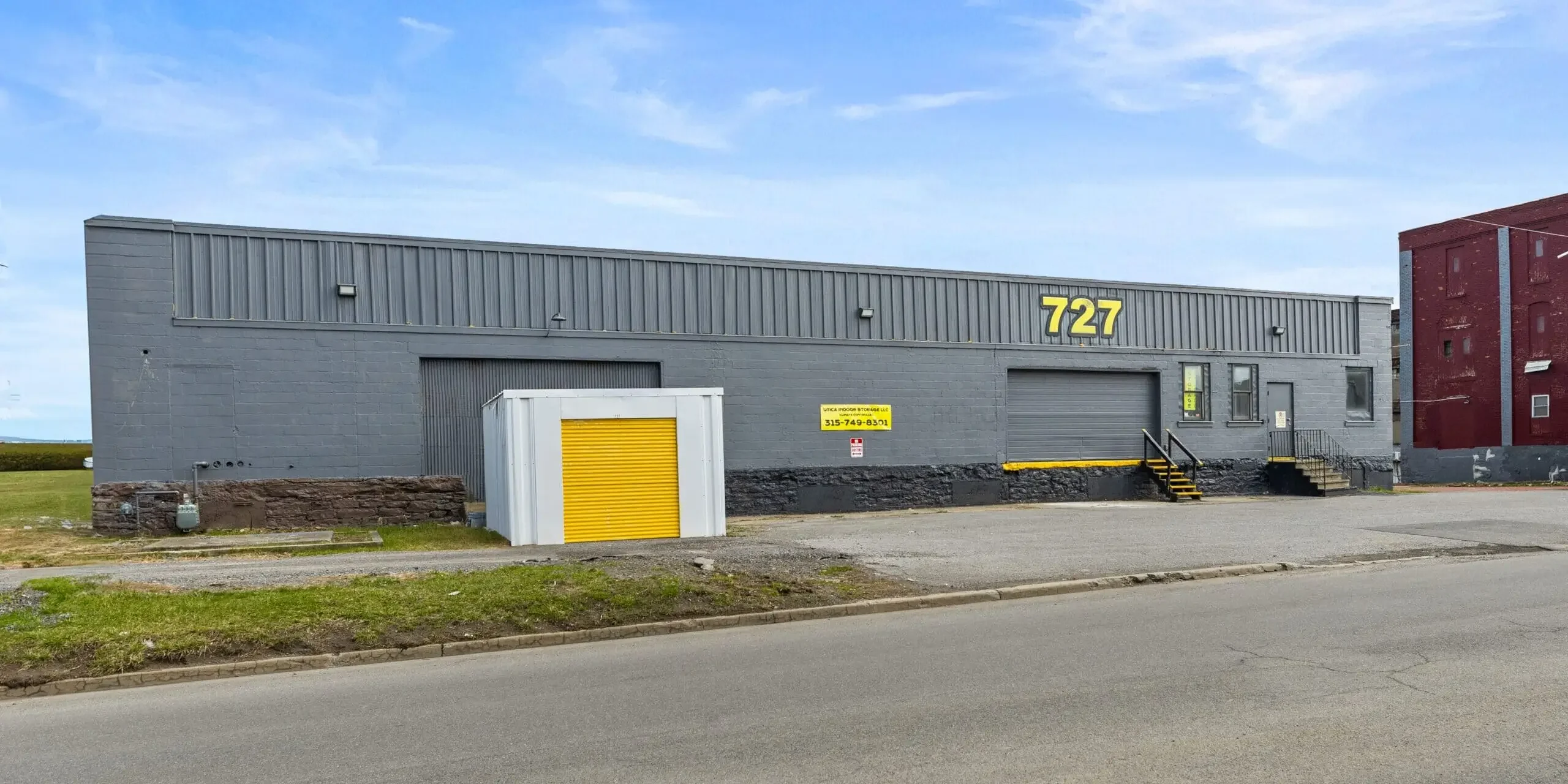 A large warehouse with a truck parked on the side of it.