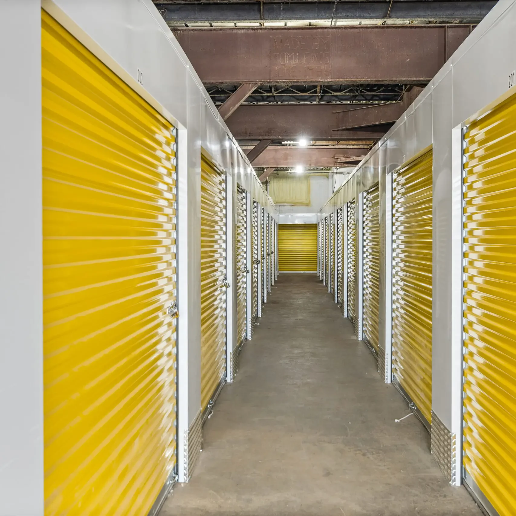 A long hallway with many yellow doors