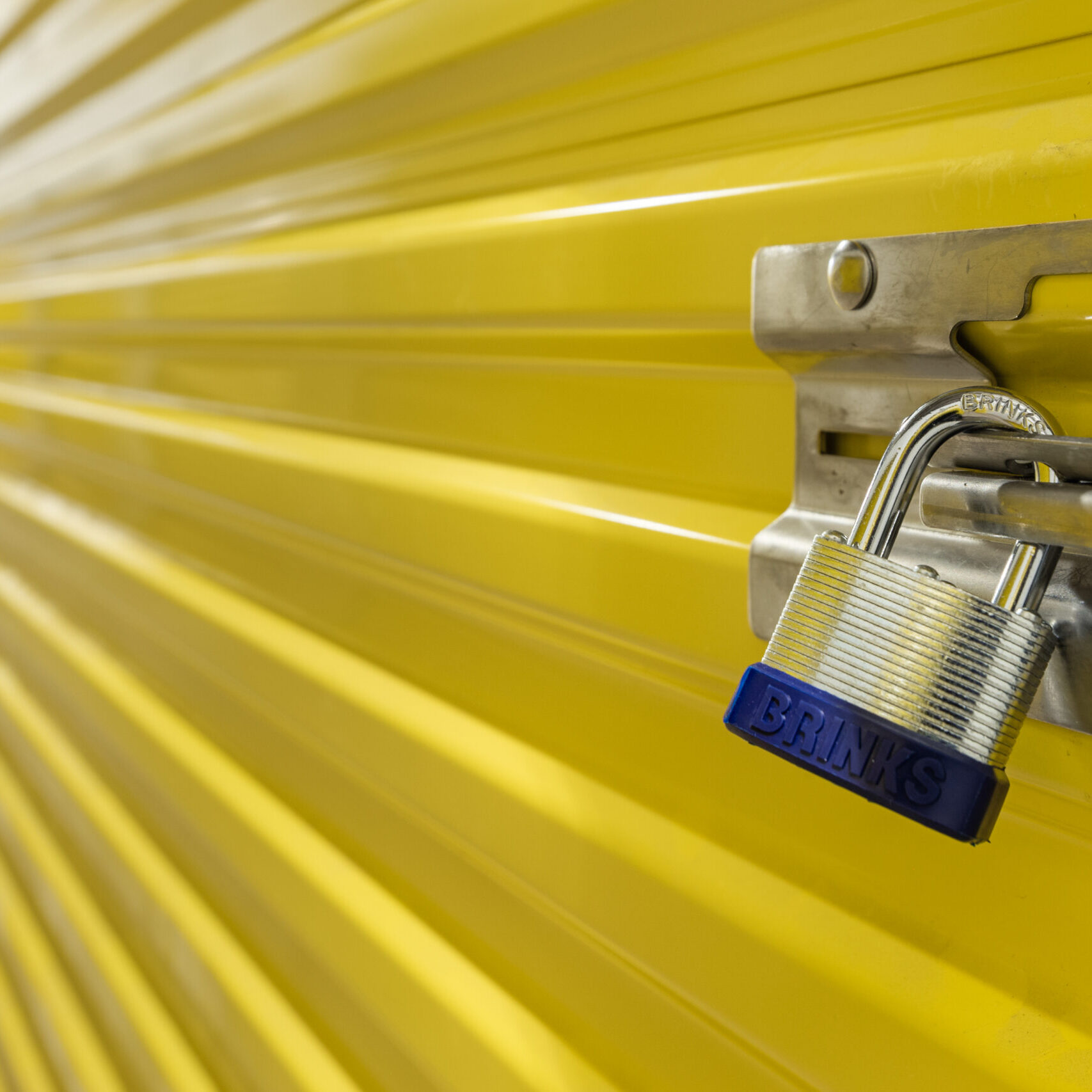 3Z0A8169 A close up of a padlock on the side of a yellow wall.